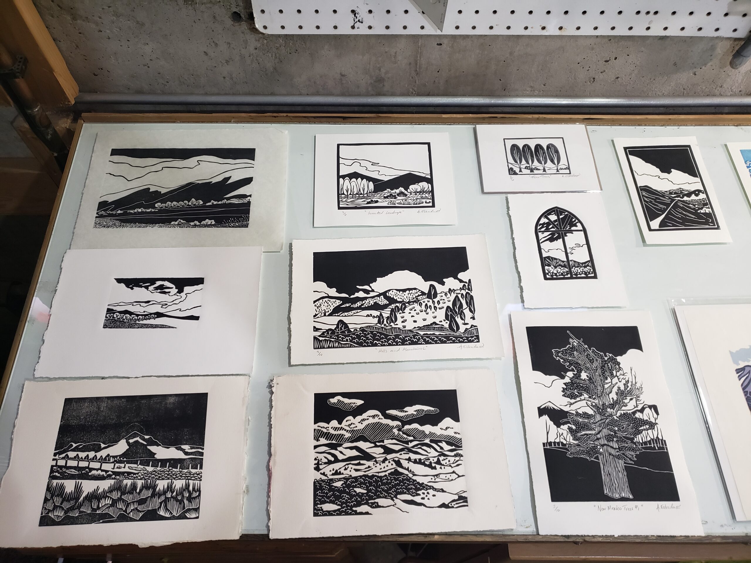 Collection of black and white landscape prints displayed on a table