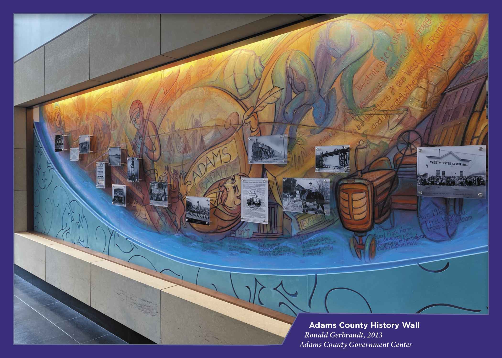 Colorful mural with historical photos, labeled "Adams County History Wall," by Ronald Gerbrandt, 2013, at Adams County Government Center.
