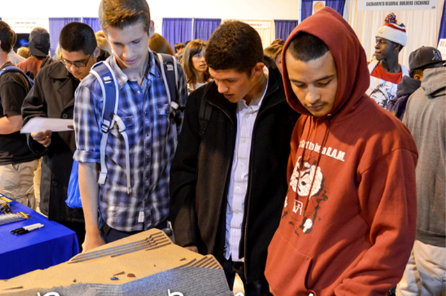Students engaged at a career fair booth, exploring options.
