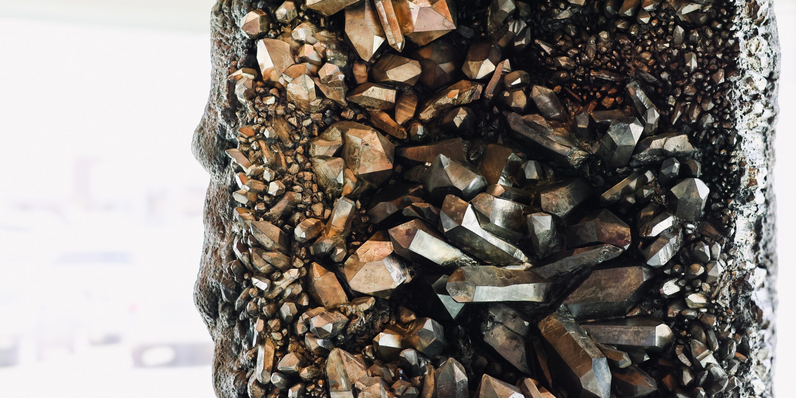 Close-up view of brown and metallic crystal formations on a rock surface.