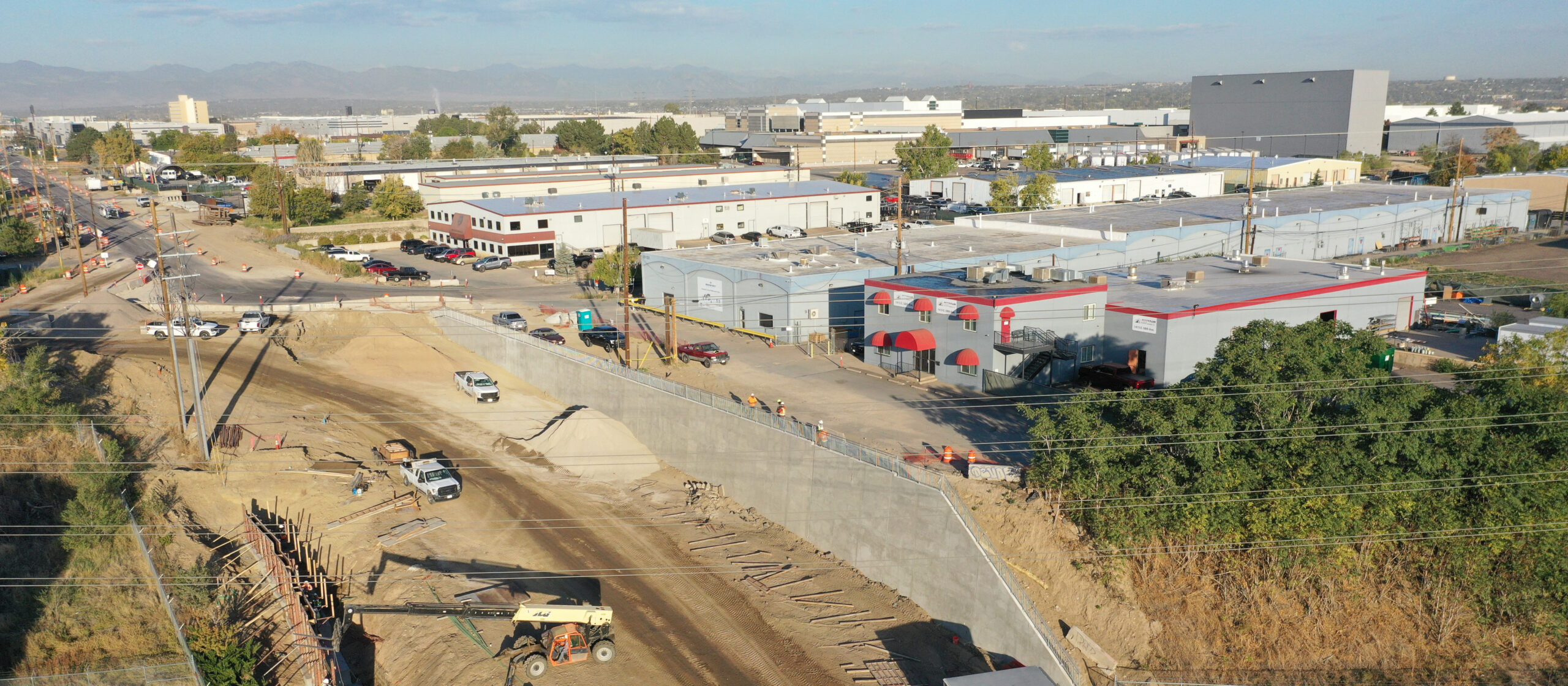 Construction site with roadwork and adjacent industrial buildings