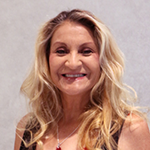 Louise Cancino smiling warmly with long blonde hair against a light background