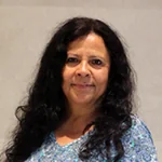 Mercedes Vasquez smiling against a plain background.