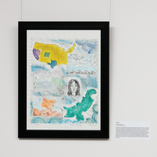 Framed artwork with abstract map elements in bright colors, surrounded by swirling patterns, includes small portrait sketch.