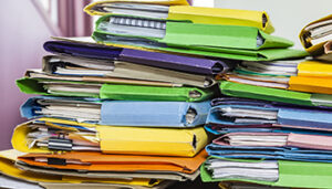 Stack of colorful file folders and papers, indicating organization or office work.