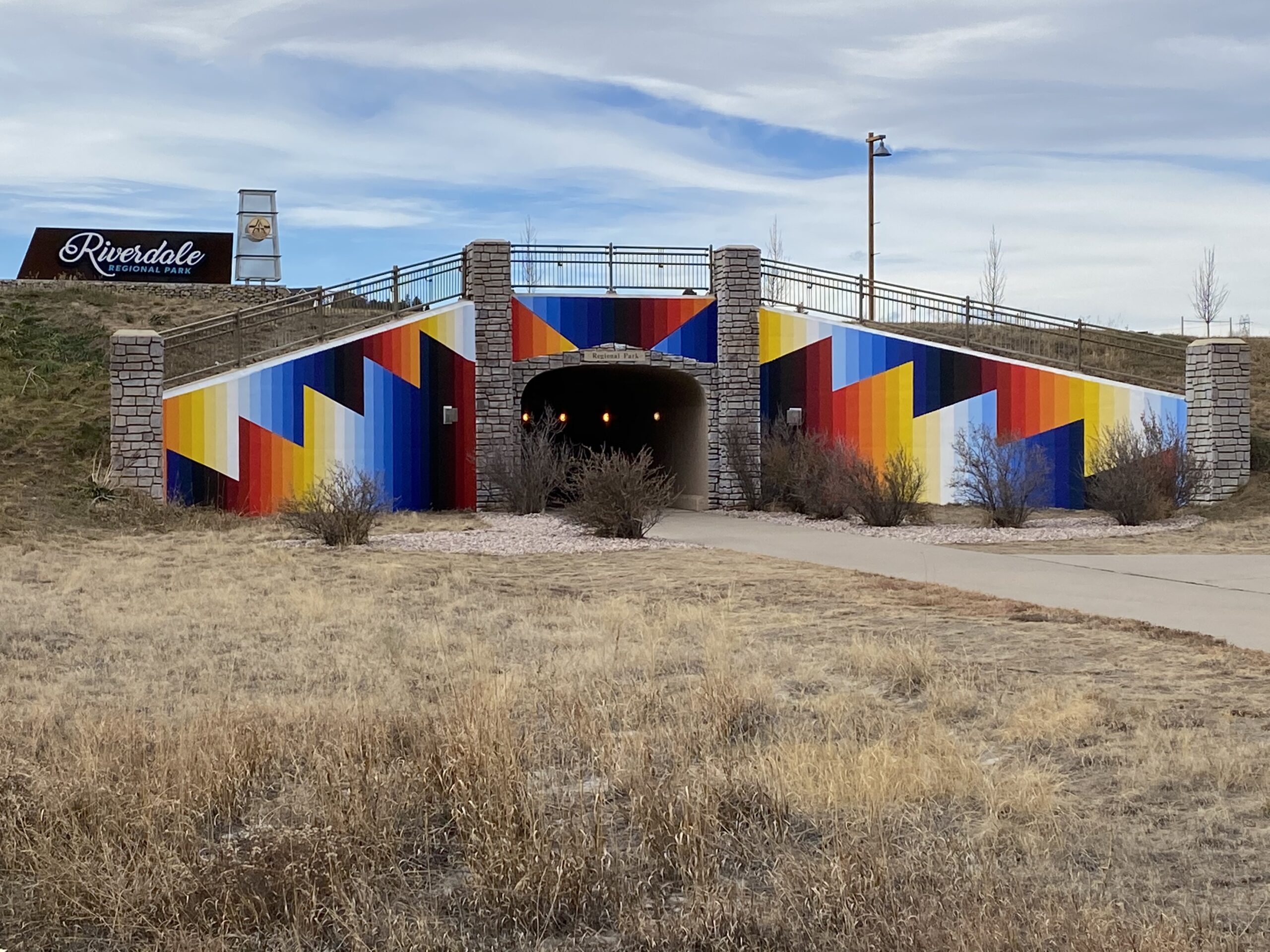 Colorful tunnel entrance with geometric patterns near Riverdale Regional Park sign