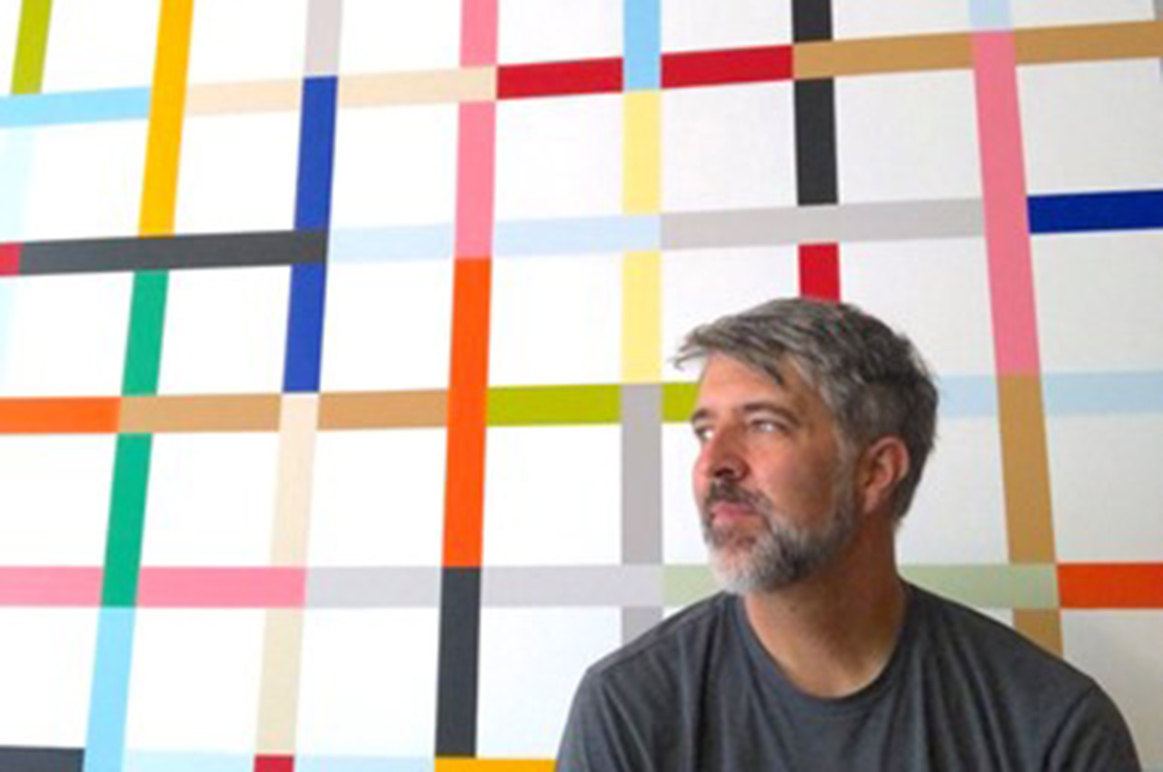 Man with gray hair and beard gazing, colorful grid background