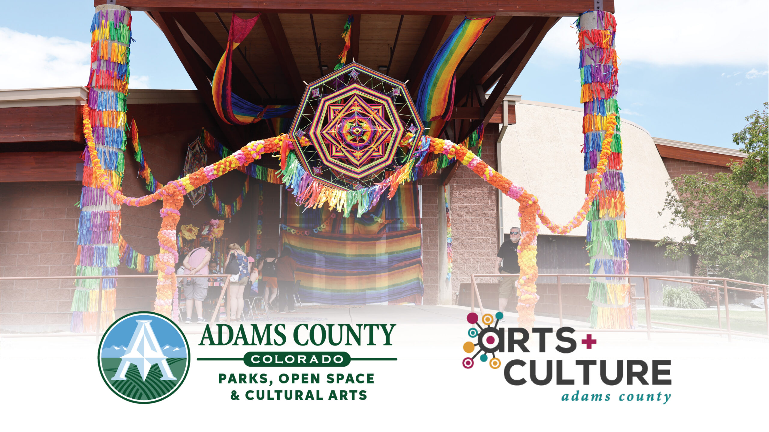 Adams County Parks, Open Space & Cultural Arts colorful festival entrance with decorations. Arts & Culture Adams County logo displayed
