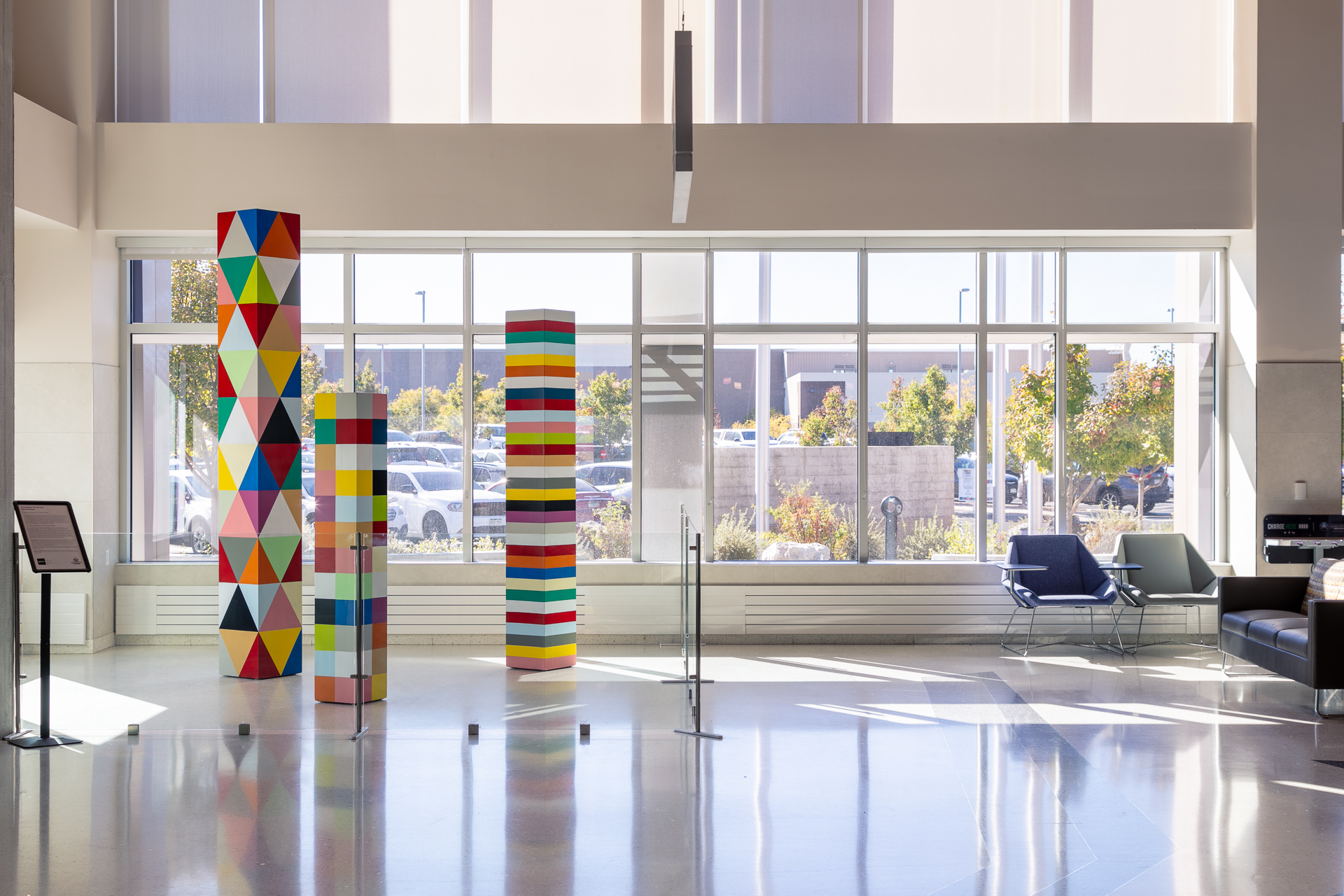 Colorful geometric sculptures in a bright lobby next to large windows