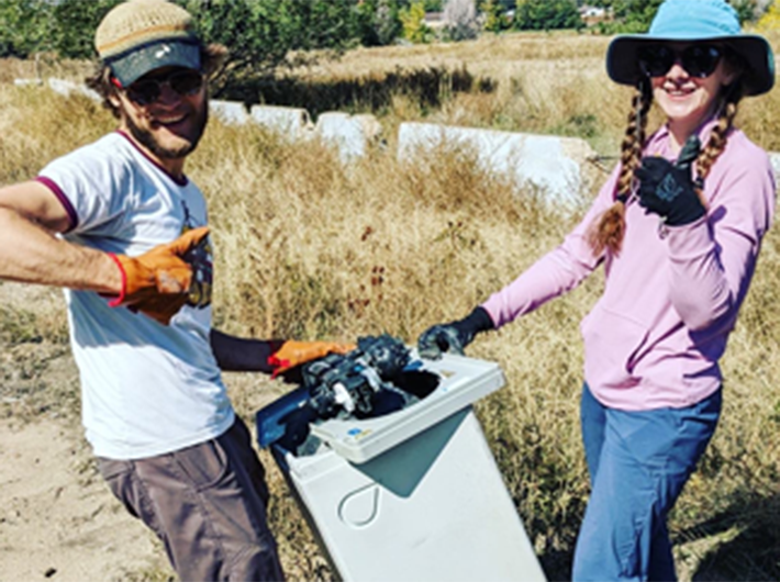 Photo-1.png shows two people outdoors, cleaning a bin, smiling and giving thumbs up gestures.