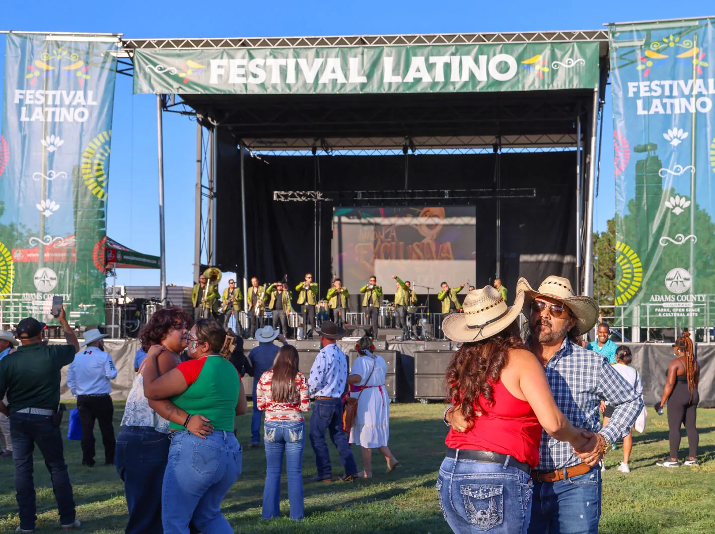 Festival Latino outdoor event; couples dance, band performs on stage