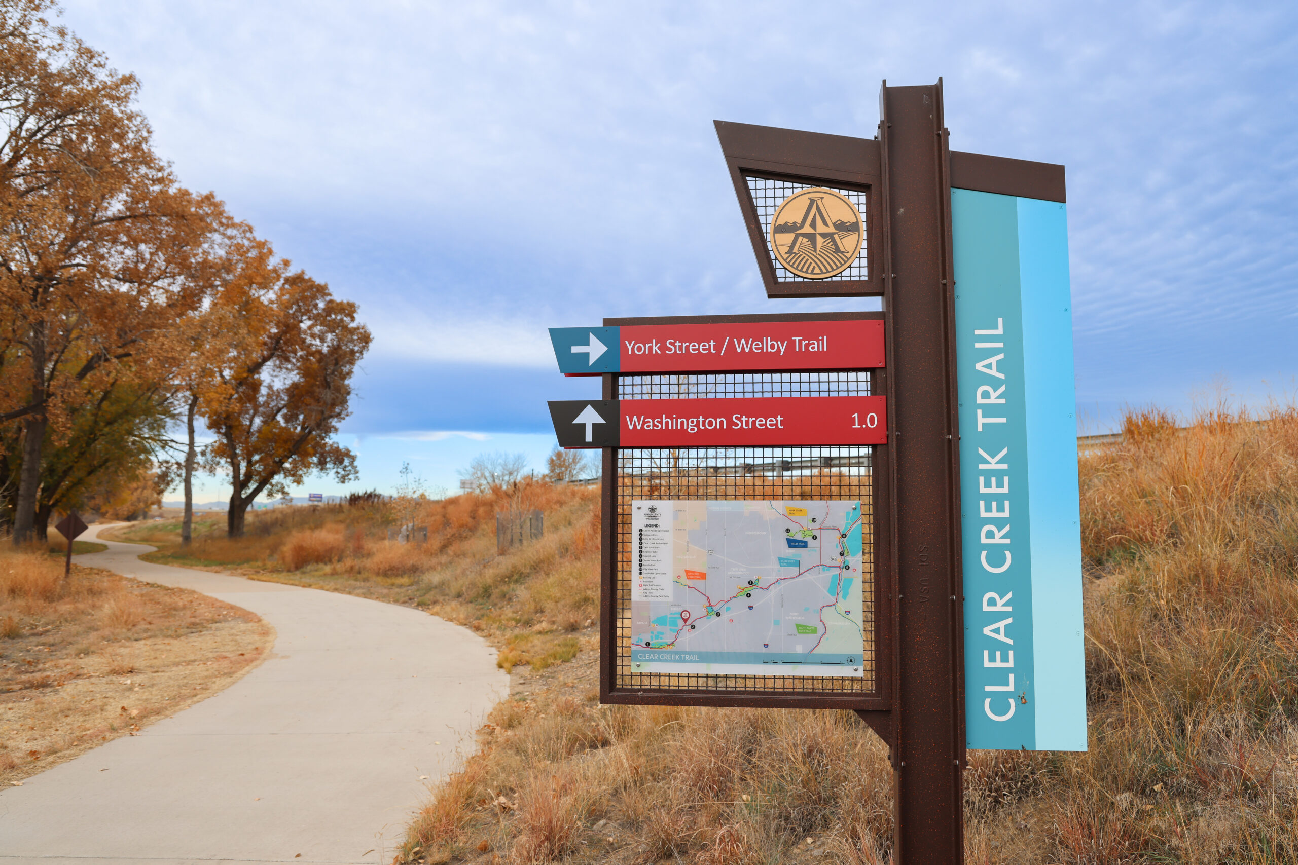 Trail sign at Clear Creek Trail with directions to York Street/Welby Trail and Washington Street