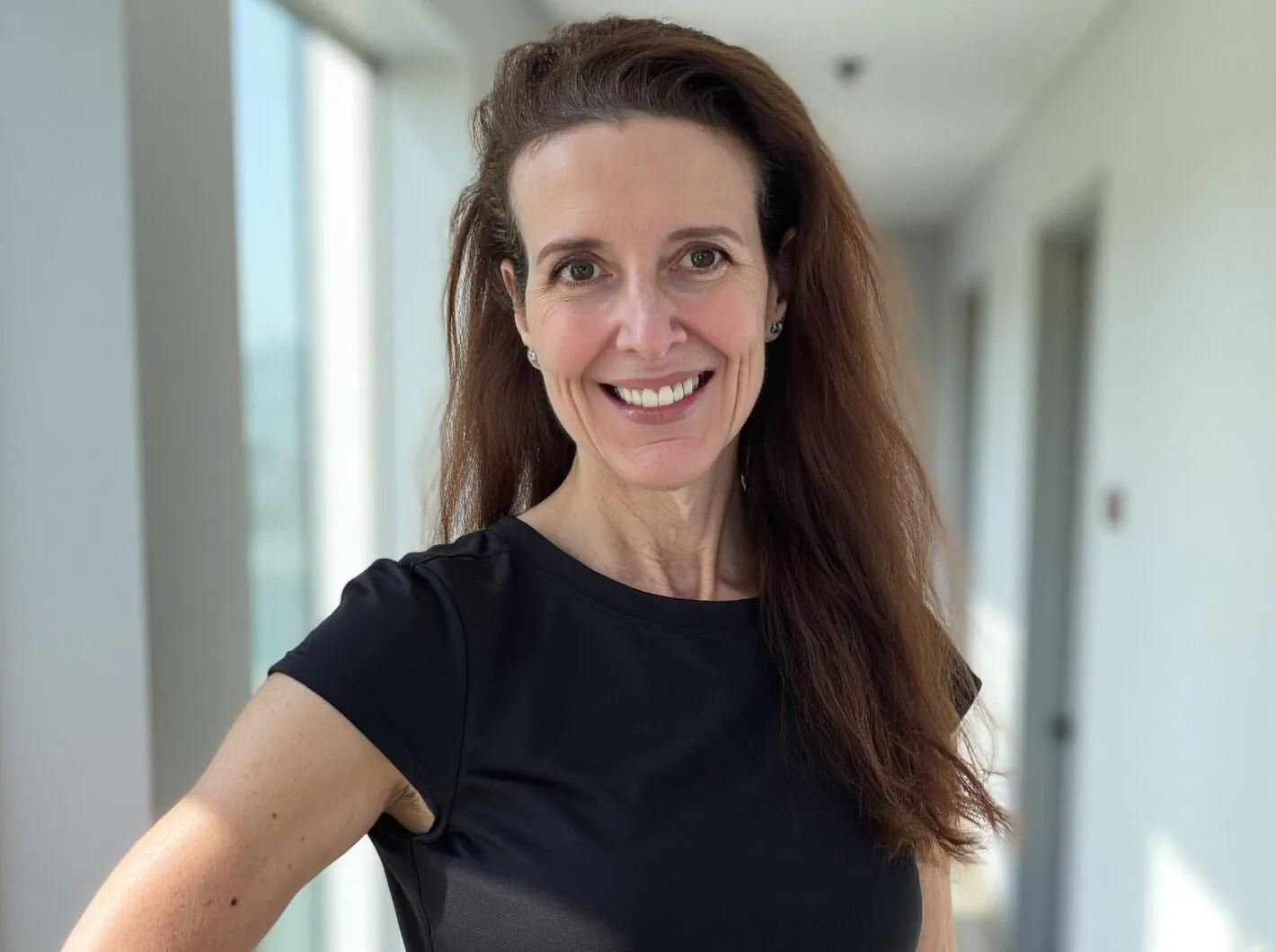 Bettina Schneider smiling in a hallway with natural light