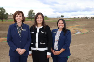 Photos of Commissioners Kathy Henson, Lynn Baca, and Julie Duran-Mullica in front of Brantner Gulch.