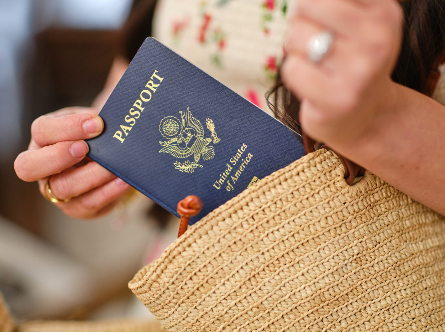 A person placing a United States passport into a woven bag
