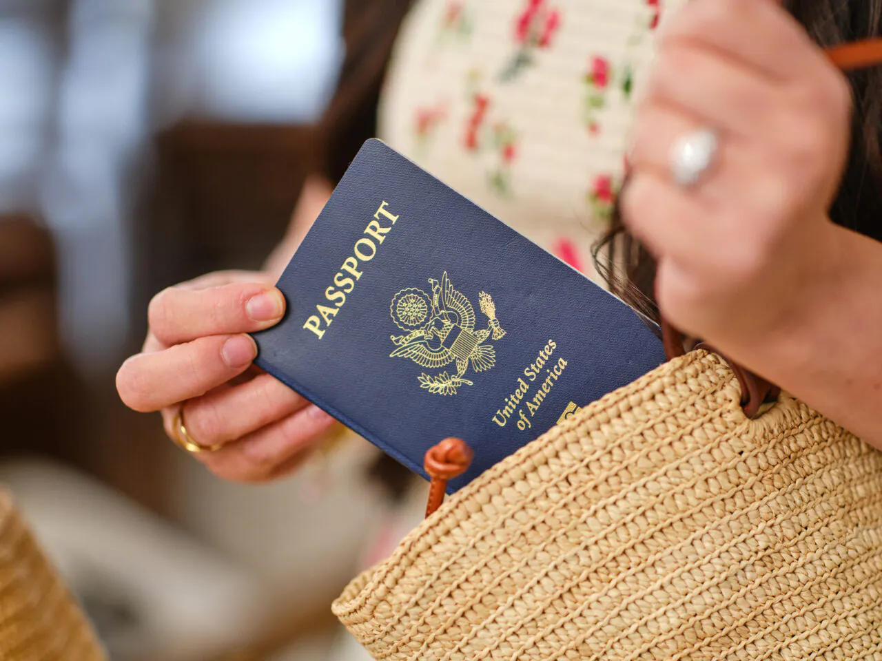 Person putting a U.S. passport into a straw bag