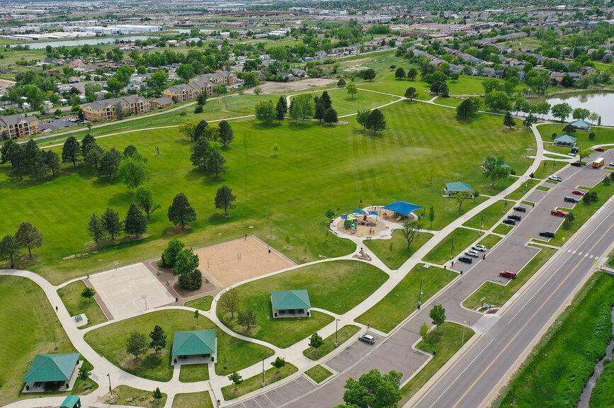 Aerial view of Rotella Park with green spaces, pathways, playgrounds, and parking areas