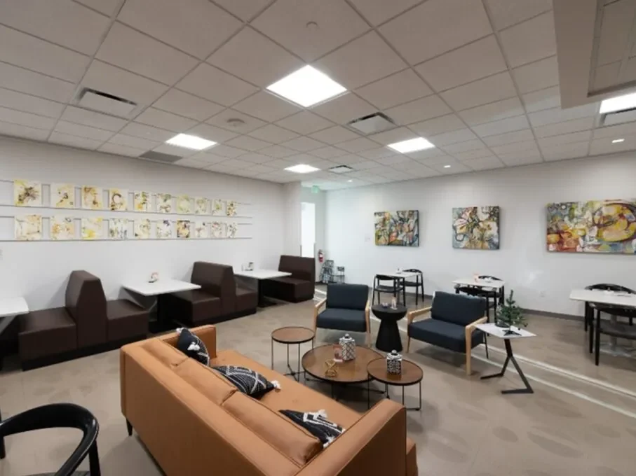 Spacious gallery lounge with modern seating, abstract art, and white tables