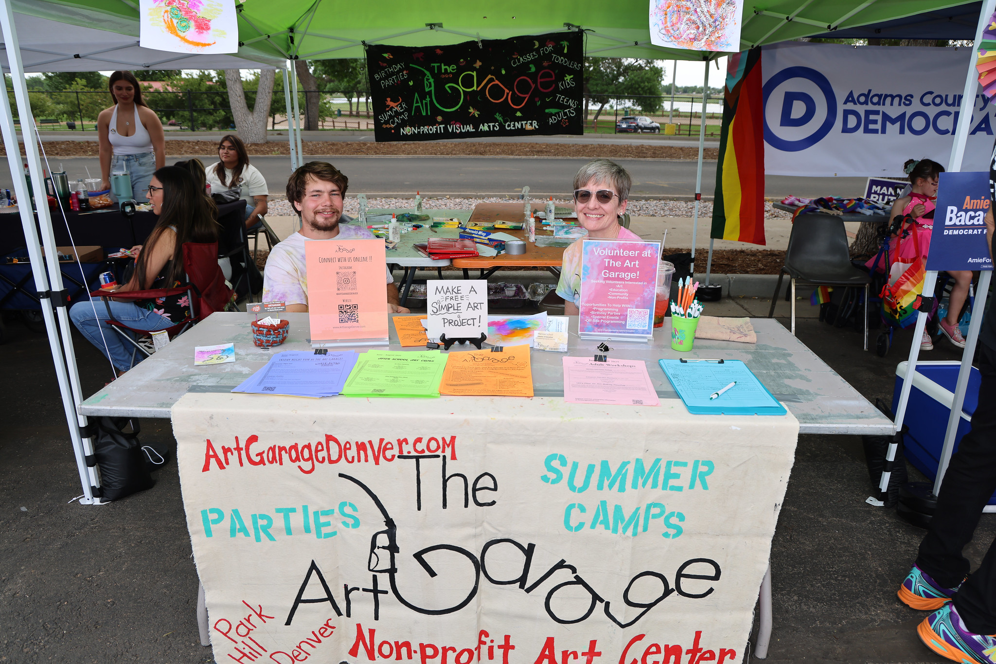 Man and woman at Art Garage booth promoting art projects and volunteering