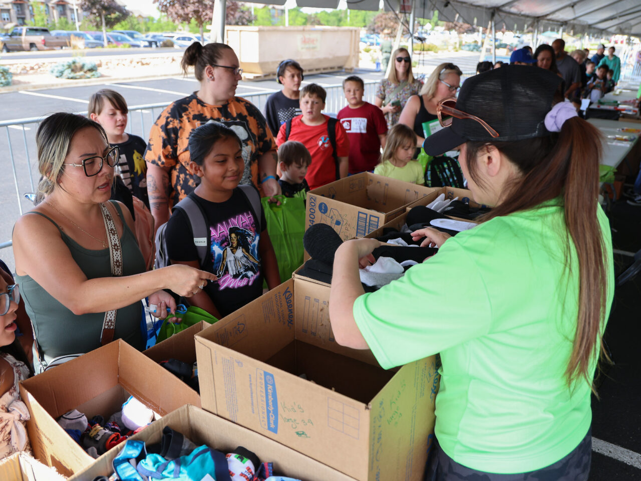 People selecting clothing from boxes at an outdoor community event