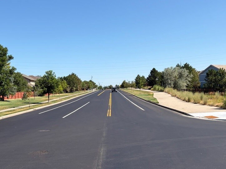 Newly paved suburban road, clear sky, few distant cars